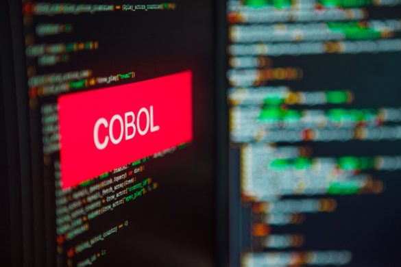 Computerscherm met programmeertaal. Op het scherm staat in rood Cobol