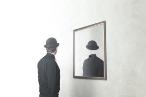 Reflectie van man met bolhoed kin de spiegel