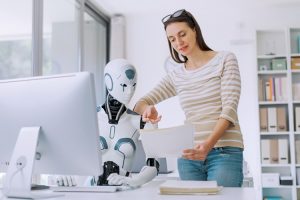 Vrouw staat naast robot achter computer