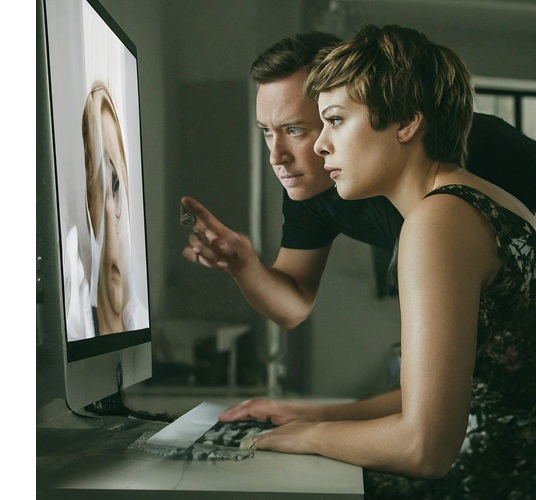 Man en vrouw kijken in beeldscherm van computer die als spiegel fungeert, AI gegenereerd