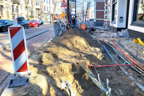 Kabels liggen in een opengegraven deel van een straat in de stad