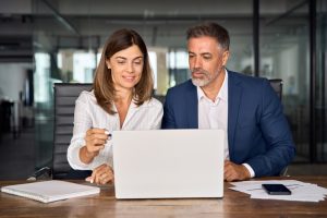 Twee ambtenaren achter een laptop