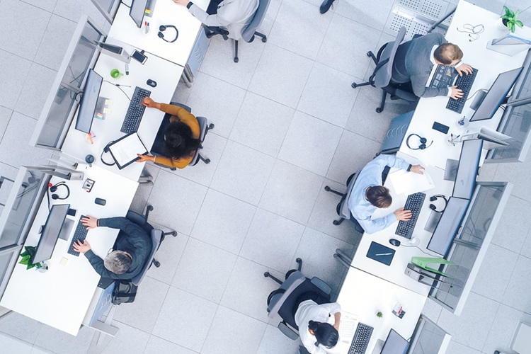 Top down genomen foto van kantoormedewerkers achter bureau met computers