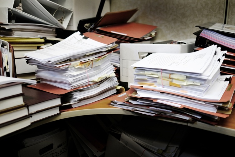 Detail,Of,A,Messy,Desk,With,Books,Binders,Files,And