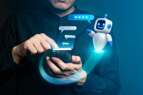 Chatbot poppetje naast hand van man die mobiele telefoon vasthoudt