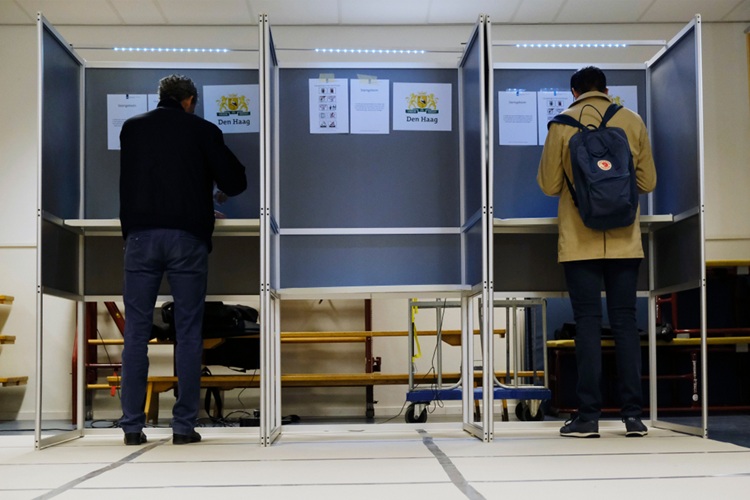 Twee mensen in stemhokjes bij verkiezingen