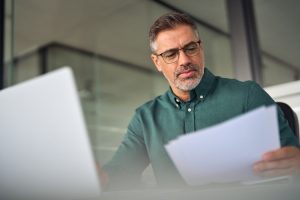 Man achter laptop bekijkt gegevens van cliënt